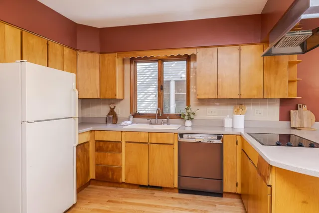 a kitchen with a refrigerator a sink and cabinets