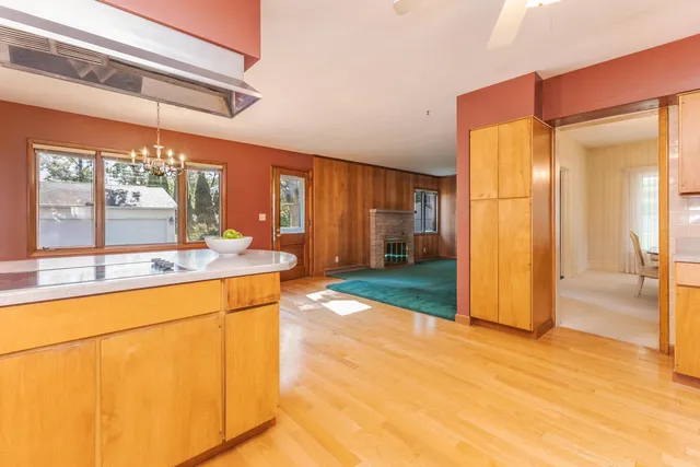 a large kitchen with kitchen island a large window a sink and stainless steel appliances