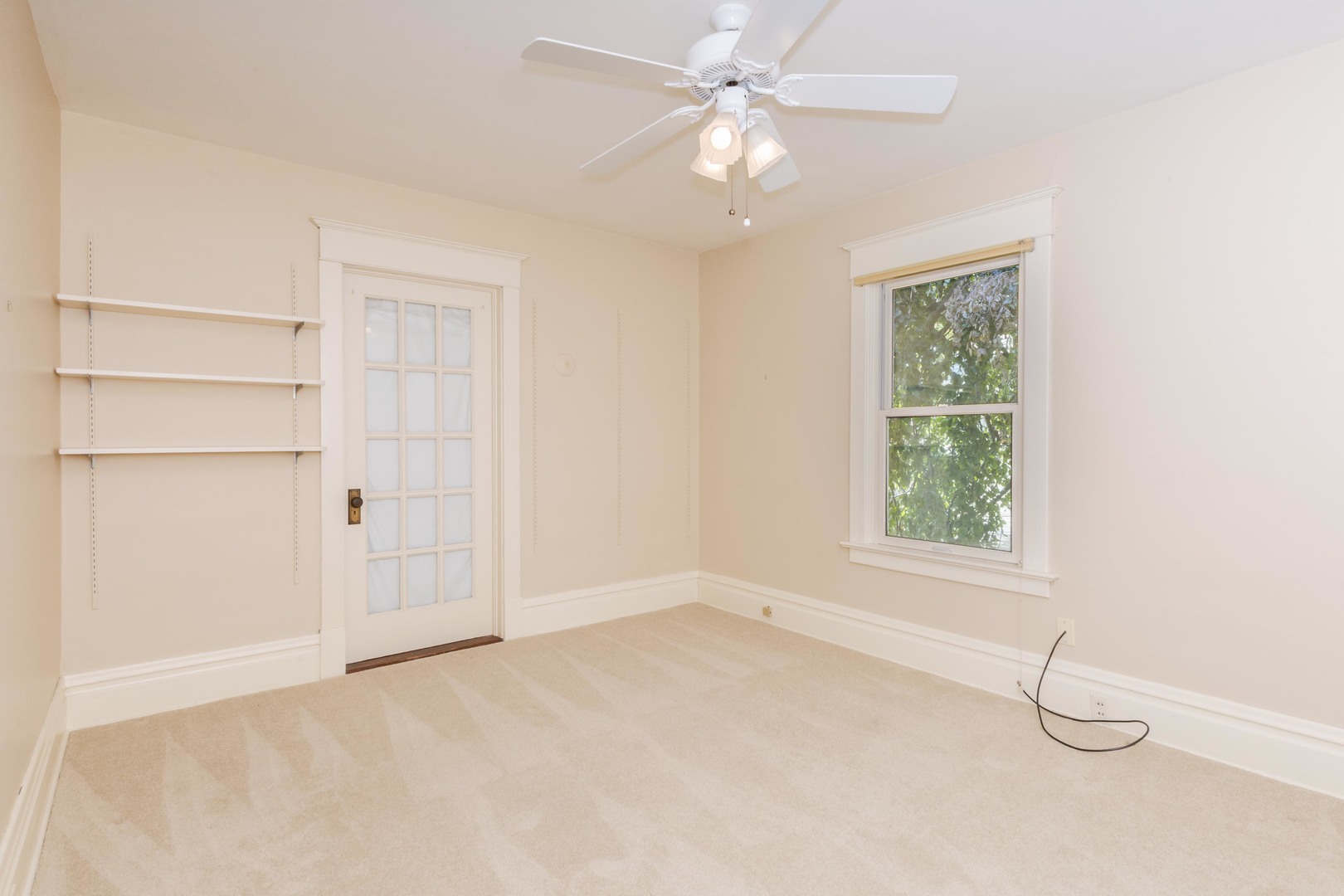 1513 East Grove Street Bloomington, IL 61701 - Photo 30 of 48 an empty room with a ceiling fan and a window