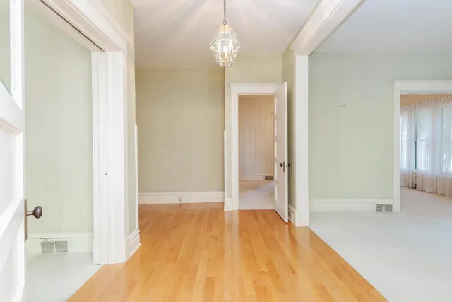 a view of a room with wooden floor and a bathroom