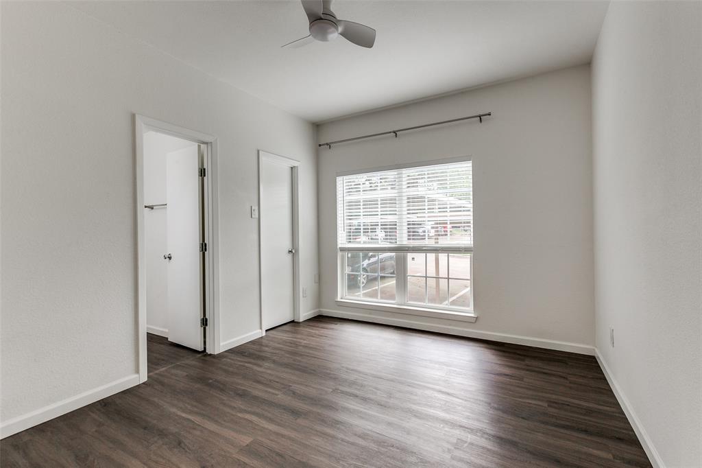 8601 Park Lane, Unit 111 Dallas, TX 75231 - Photo 15 of 18 an empty room with wooden floor and windows