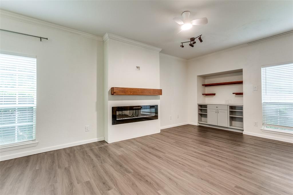8601 Park Lane, Unit 111 Dallas, TX 75231 - Photo 6 of 18 an empty room with wooden floor fireplace and windows