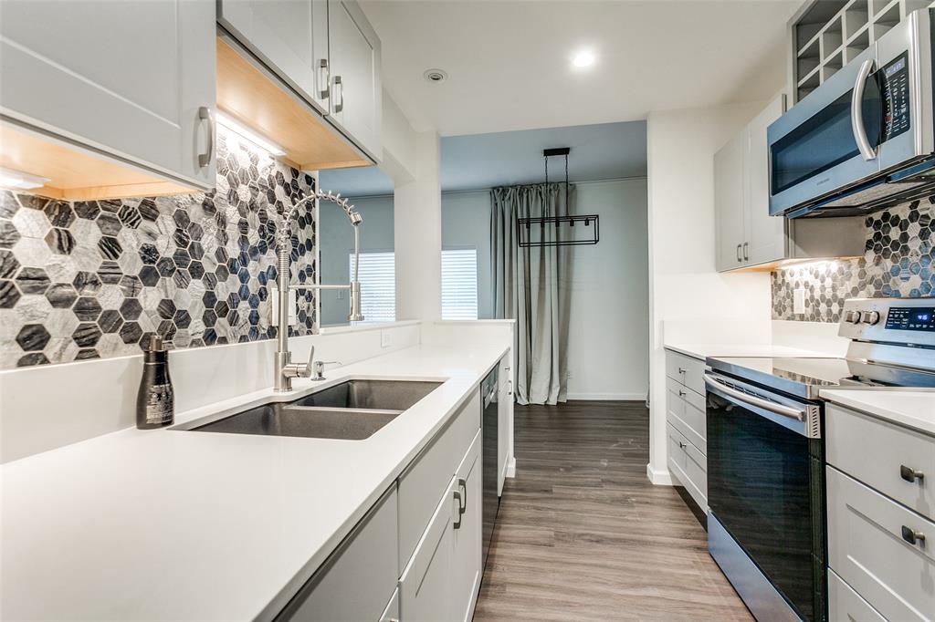 8601 Park Lane, Unit 111 Dallas, TX 75231 - Photo 10 of 18 a kitchen with stainless steel appliances granite countertop a sink and a refrigerator