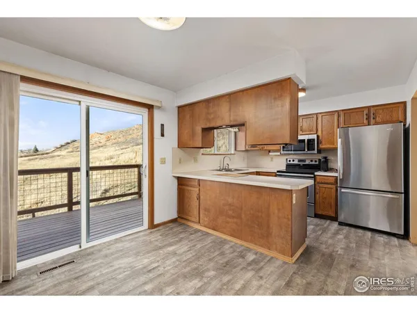 a kitchen with a refrigerator a stove top oven and a large window