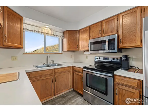a kitchen with stainless steel appliances a stove a sink a microwave a refrigerator and cabinets
