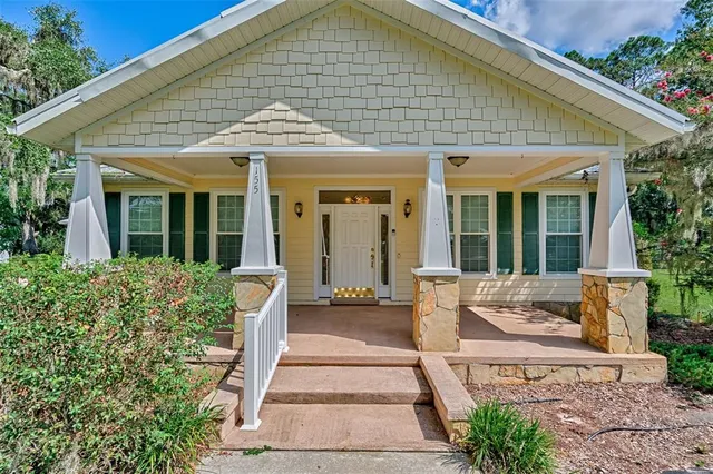 a front view of a house with a garden and plants