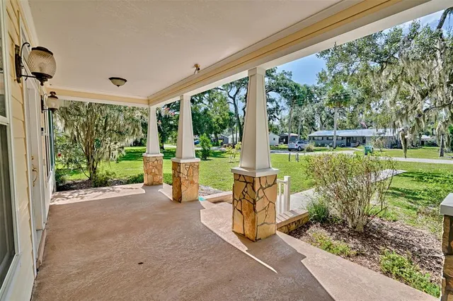 a view of a house with a yard and potted plants