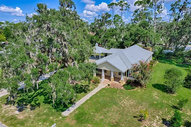 an aerial view of residential house with outdoor space and trees all around