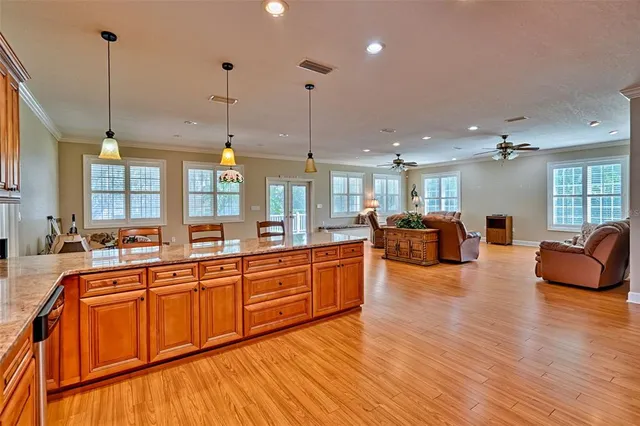 a large kitchen with stainless steel appliances kitchen island granite countertop a sink a stove and a refrigerator