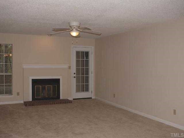 106 Choptank Court Cary, NC 27513 - Photo 3 of 12 an empty room with a fireplace and fan