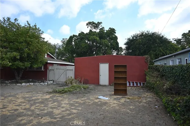 a backyard of a house with plants and tree