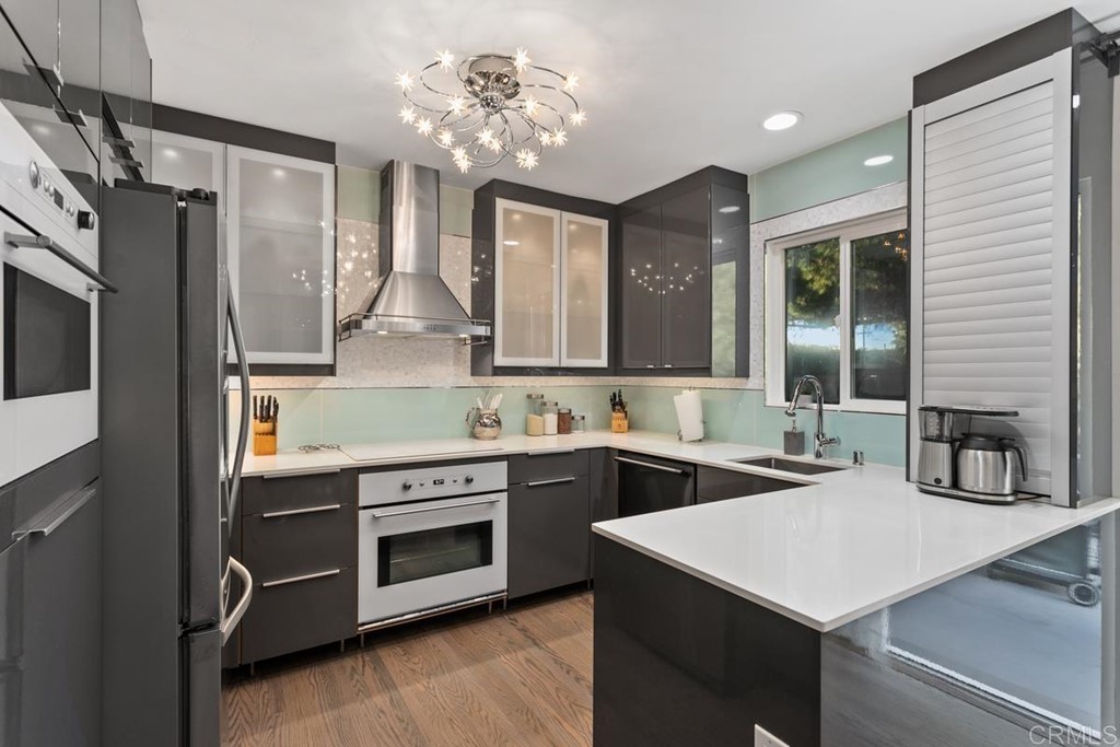 990 Laguna Drive Carlsbad, CA 92008 - Photo 6 of 21 a kitchen that has a sink a stove and chairs