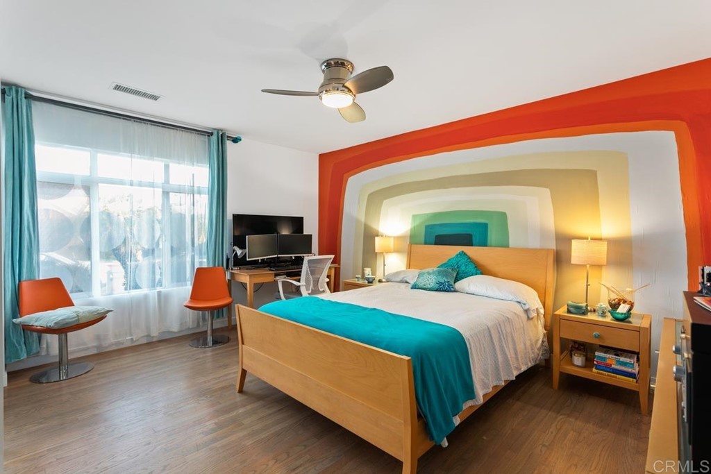 990 Laguna Drive Carlsbad, CA 92008 - Photo 8 of 21 a bedroom with a bed a flat screen tv and a couch