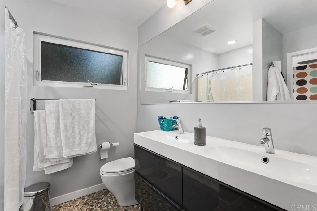 990 Laguna Drive Carlsbad, CA 92008 - Photo 9 of 21 a bathroom with a sink toilet a mirror and shower