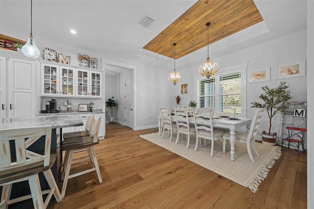 11707 Southeast 101st Court Road Belleview, FL 34420 - Photo 27 of 84 a dining room with wooden floor and large window