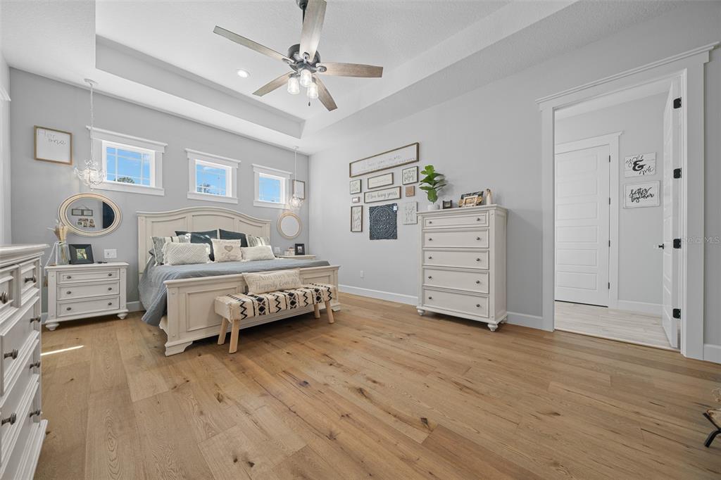 11707 Southeast 101st Court Road Belleview, FL 34420 - Photo 32 of 84 a bedroom with furniture and a chandelier