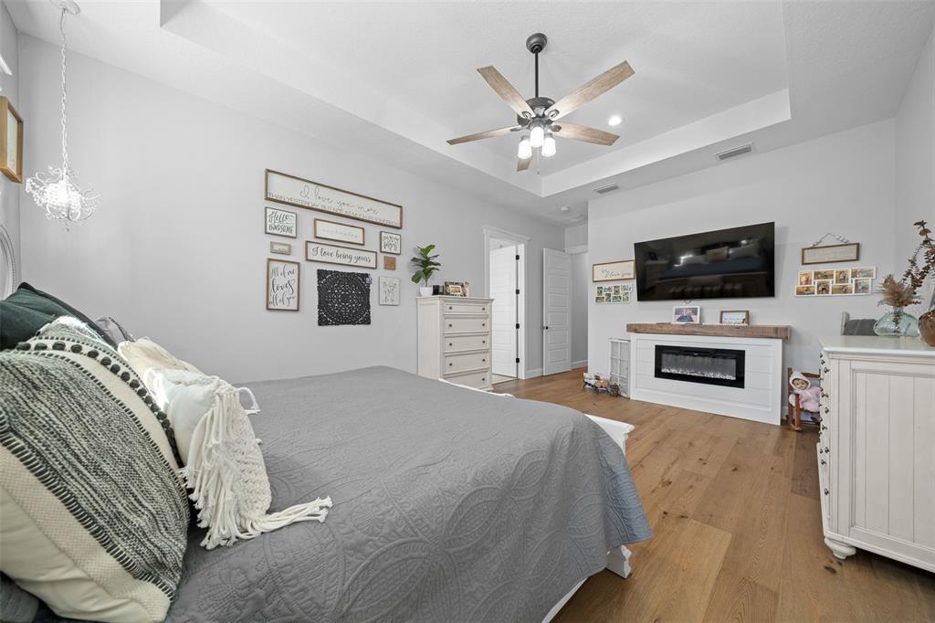 11707 Southeast 101st Court Road Belleview, FL 34420 - Photo 33 of 84 a bedroom with a large bed and a flat screen tv