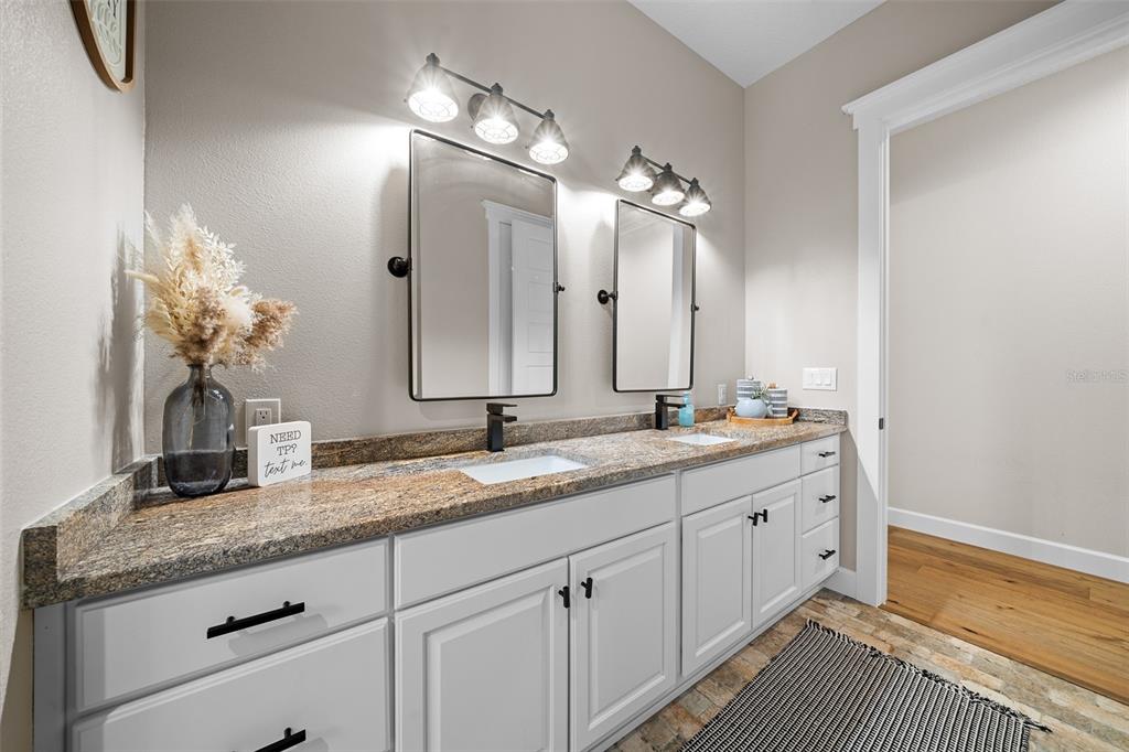 11707 Southeast 101st Court Road Belleview, FL 34420 - Photo 34 of 84 a bathroom with a granite countertop double vanity sink and a mirror