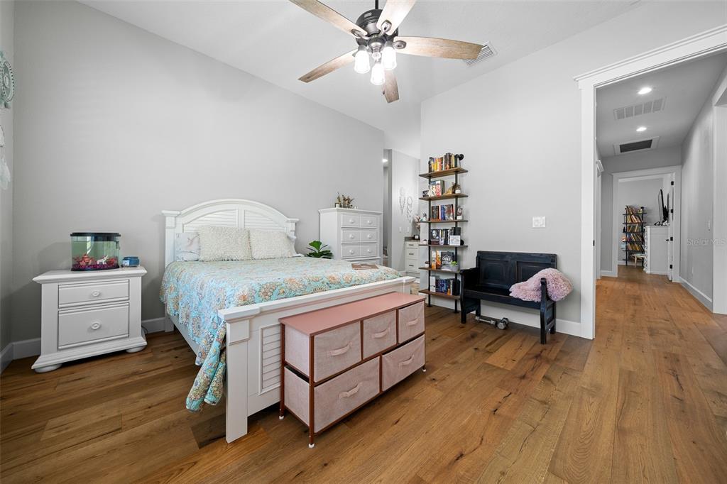 11707 Southeast 101st Court Road Belleview, FL 34420 - Photo 44 of 84 a bedroom with a bed and a chandelier