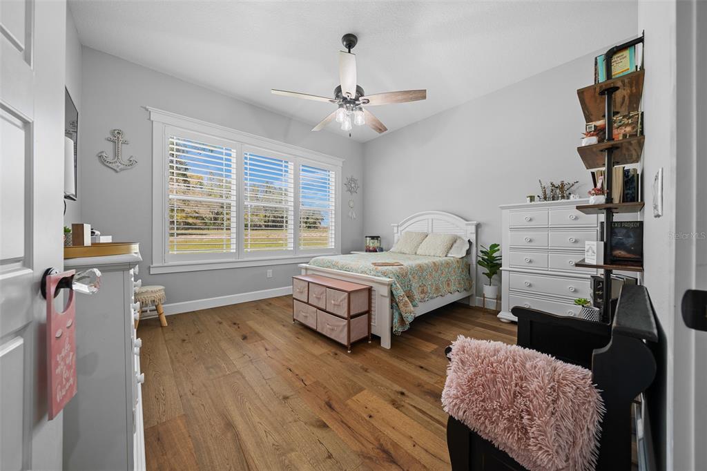 11707 Southeast 101st Court Road Belleview, FL 34420 - Photo 46 of 84 a bedroom with a bed wooden floor and window