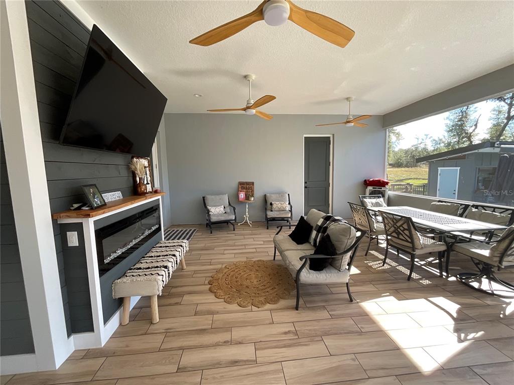 11707 Southeast 101st Court Road Belleview, FL 34420 - Photo 54 of 84 a living room with furniture a flat screen tv and kitchen view