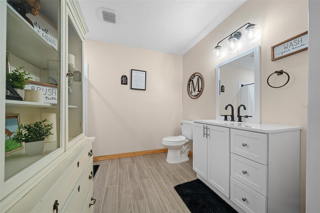 11707 Southeast 101st Court Road Belleview, FL 34420 - Photo 75 of 84 a spacious bathroom with a toilet sink and mirror