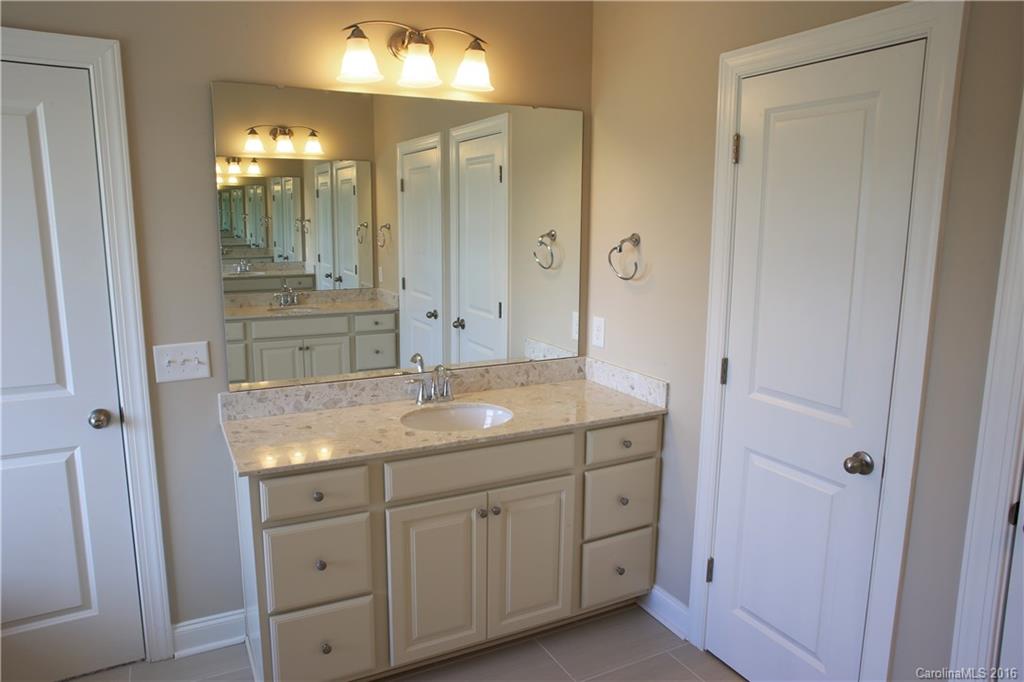 294 Helton Lane, Unit 8 Fort Mill, SC 29708 - Photo 13 of 19 a bathroom with a granite countertop sink mirror and shower