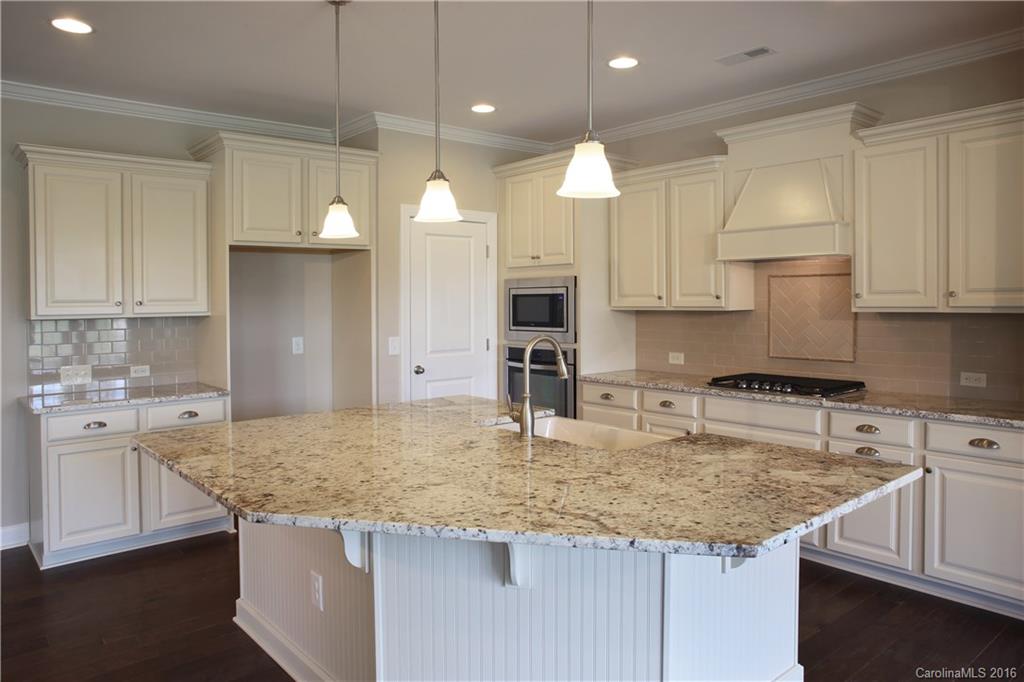 294 Helton Lane, Unit 8 Fort Mill, SC 29708 - Photo 4 of 19 a kitchen with kitchen island granite countertop a sink a center island and cabinets