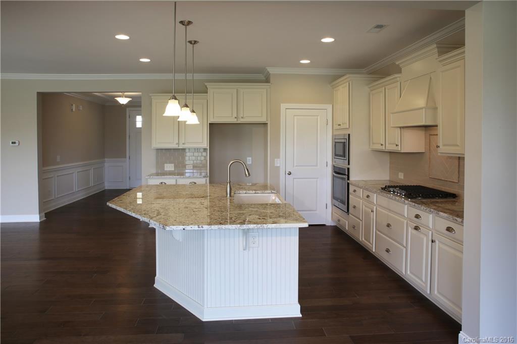 294 Helton Lane, Unit 8 Fort Mill, SC 29708 - Photo 6 of 19 a kitchen with kitchen island granite countertop a stove a sink and a refrigerator