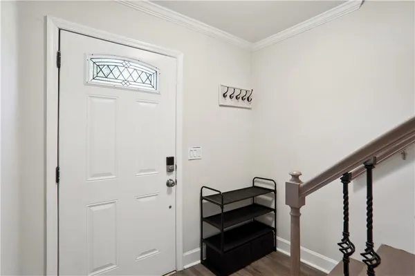 a view of a hallway with wooden floor and stairs