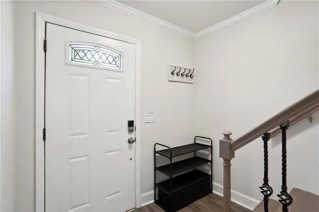 a view of a hallway with wooden floor and stairs