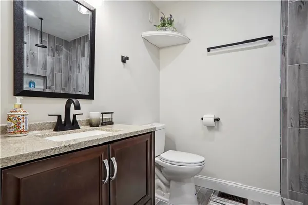 a bathroom with a granite countertop sink toilet and shower