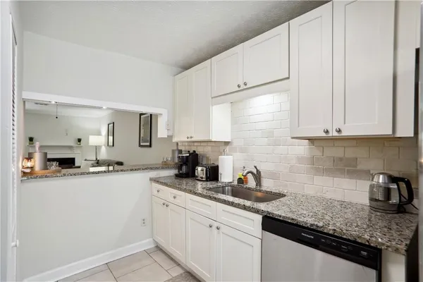 a kitchen with granite countertop white cabinets and white appliances