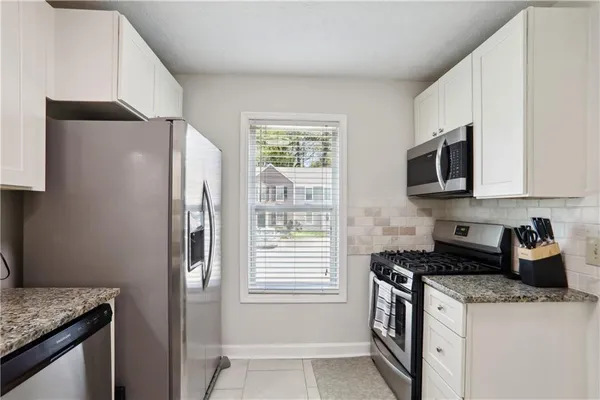 a kitchen with stainless steel appliances granite countertop a refrigerator and a stove top oven