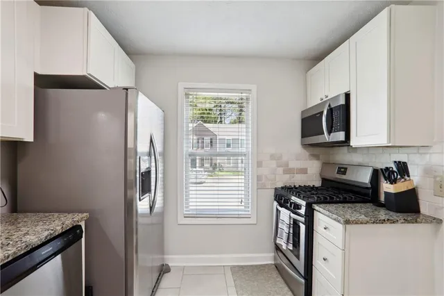 a kitchen with stainless steel appliances granite countertop a refrigerator and a stove top oven