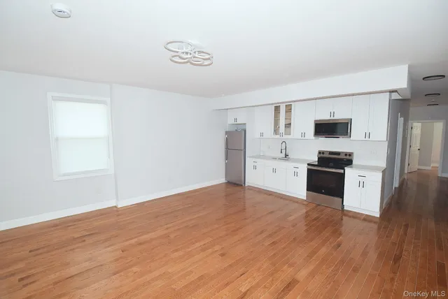 a kitchen with granite countertop a refrigerator and a stove top oven