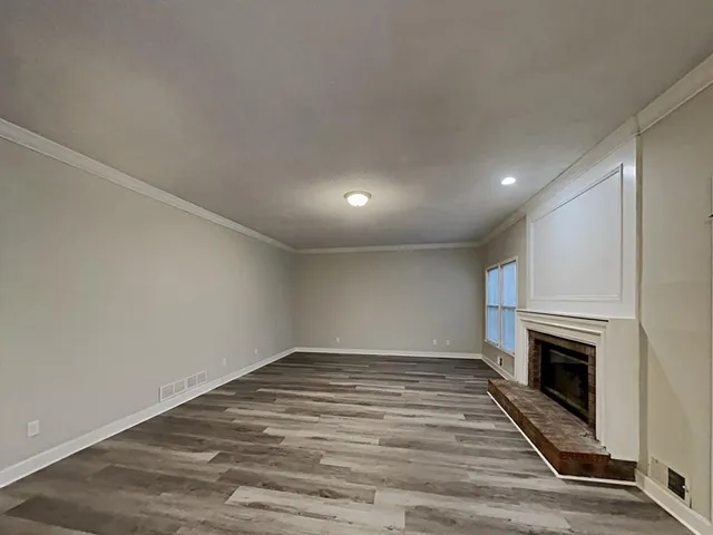 a view of empty room with wooden floor and fireplace