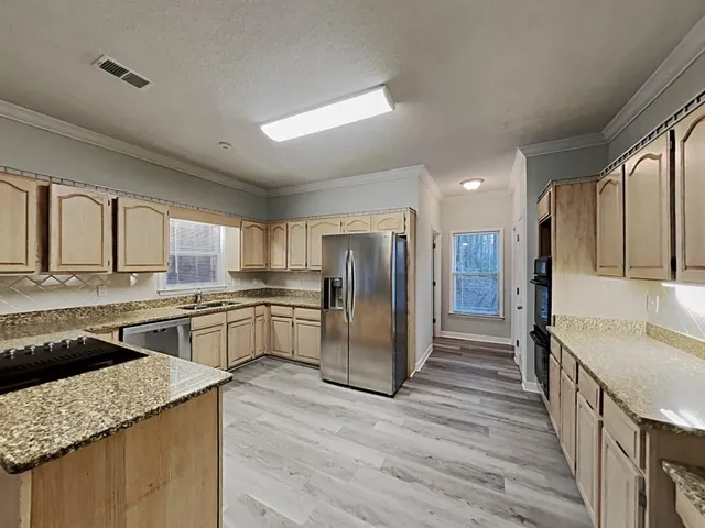 a large kitchen with a center island and stainless steel appliances