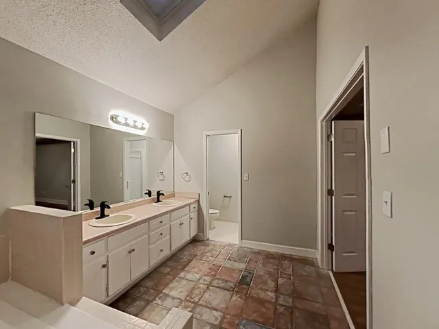 a spacious bathroom with a double vanity sink a mirror and a shower