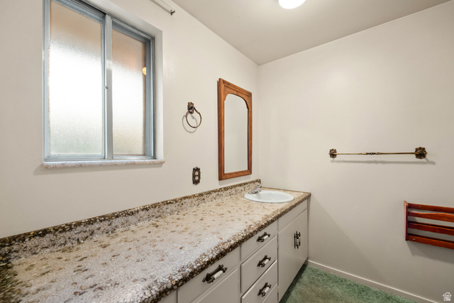 1940 West Old Hwy Road Morgan, UT 84050 - Photo 38 of 73 Bathroom featuring a built-in vanity with a speckled countertop, integrated sink, and white cabinetry
