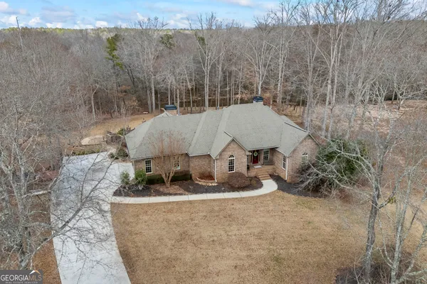 a front view of a house with a yard covered with trees