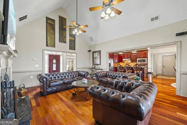 a living room with furniture and a wooden floor