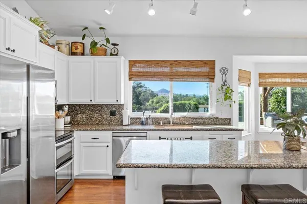 a kitchen with stainless steel appliances granite countertop a refrigerator and a stove