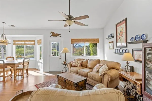 a view of a livingroom and dining room with furniture window and wooden floor