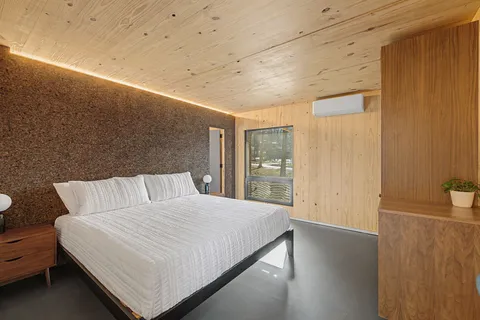 a large bed sitting in a room next to a window