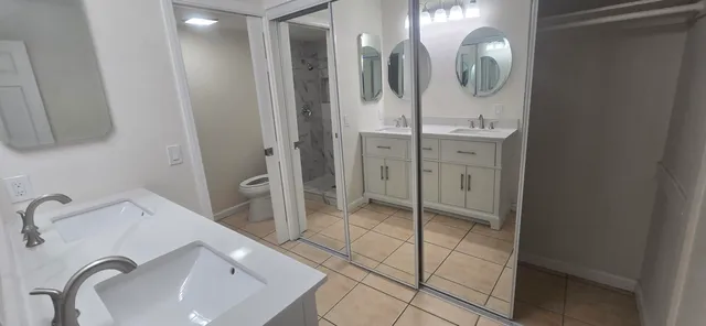 a spacious bathroom with a double vanity sink and a mirror