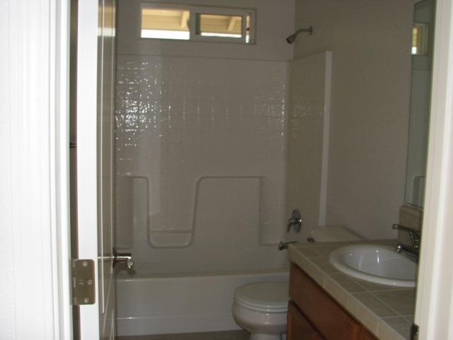 7550 Pit Road Redding, CA 96001 - Photo 12 of 20 a bathroom with a granite countertop toilet a sink and shower