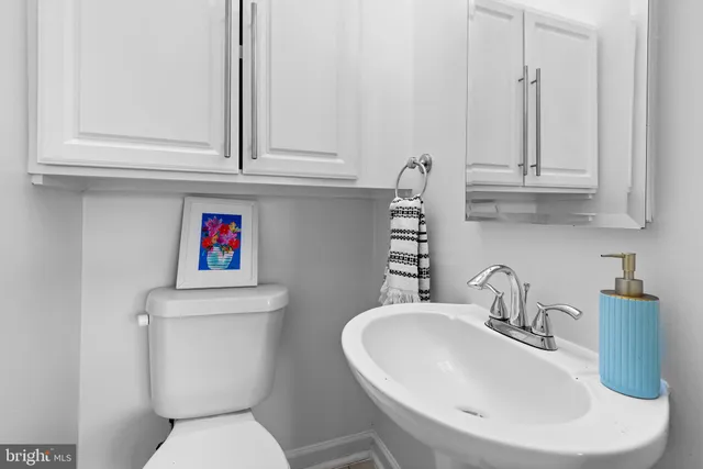 a bathroom with a toilet sink and mirror