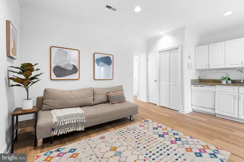 a living room with furniture and painting on the wall