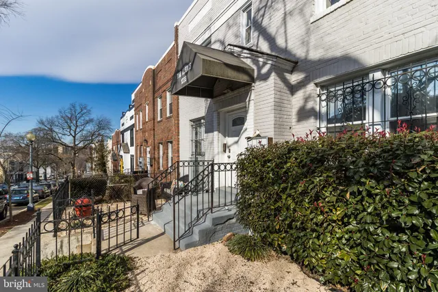 a view of a house with a small yard and potted plants